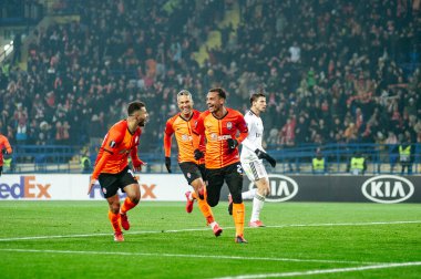 Kharkiv, Ukraine - February 20, 2020:  Alan Patrik and Junior Moraes, Viktor Kovalenko happy and fun celebrating goal in match Europa League Shakhtar - Benfica