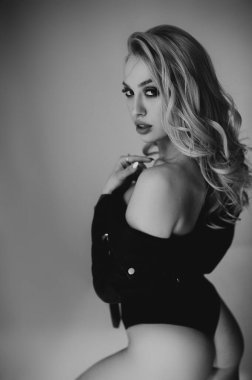 Bedensel. Sarışın, genç bir kadının tek renkli portresi. İç çamaşırları ve kertenkele ceketiyle poz veren güzel görünümlü bir manken..