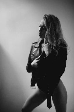 Bedensel. Sarışın, genç bir kadının tek renkli portresi. İç çamaşırları ve kertenkele ceketiyle poz veren güzel görünümlü bir manken..