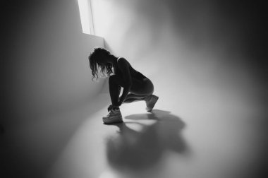 Beyaz siyah arka planda iç çamaşırlarıyla poz veren cazibeli sarışın kız. Karanlık odada baştan çıkarıcı bir kız iç çamaşırının portresi. Film kazancı olan sade bir fotoğraf.