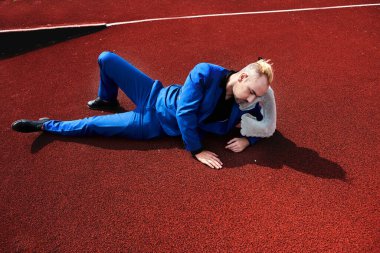 Uyku vakti. Adam yorgun uyuyor Stadyumdaki pistte yatıyor.