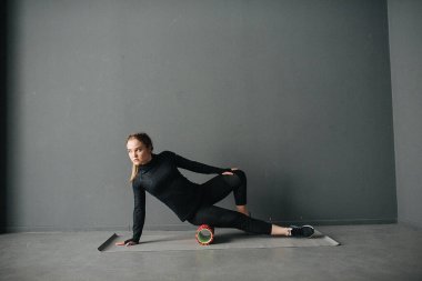 Beyaz kadın sporcu, pilates stüdyosunda kaslarını esnetiyor. Fotoğraf kazancı ile fotoğraf ayarla.