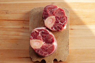 Yanında birkaç damla kan ve et olan iki parça ya da büyük kemik. Kemikler masaya konur..