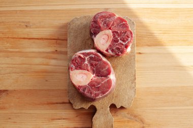 Yanında birkaç damla kan ve et olan iki parça ya da büyük kemik. Kemikler masaya konur..