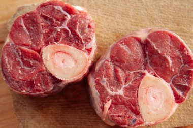 Yanında birkaç damla kan ve et olan iki parça ya da büyük kemik. Kemikler masaya konur..