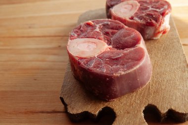 Yanında birkaç damla kan ve et olan iki parça ya da büyük kemik. Kemikler masaya konur..