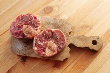 Yanında birkaç damla kan ve et olan iki parça ya da büyük kemik. Kemikler masaya konur..