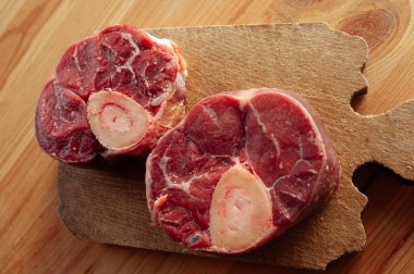 Yanında birkaç damla kan ve et olan iki parça ya da büyük kemik. Kemikler masaya konur..