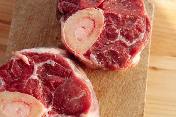 Yanında birkaç damla kan ve et olan iki parça ya da büyük kemik. Kemikler masaya konur..