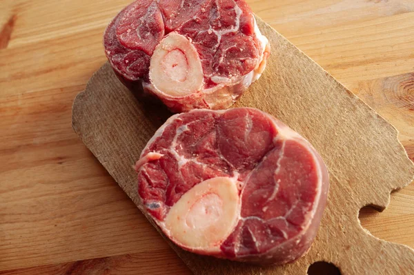 Yanında birkaç damla kan ve et olan iki parça ya da büyük kemik. Kemikler masaya konur..