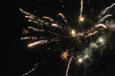 Kara gökyüzü arka planında renkli havai fişekler. Tatil sanatı geçmişi. Uzun pozlama 