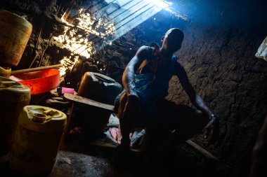 Kenya 'da gülümseyen bir Masai savaşçısının portresi geleneksel boncuklu mücevherler takıyor ve çiçeklerle süslenmiş eşsiz bir başlık takıyor. Otantik Afrika kabile kültürü.