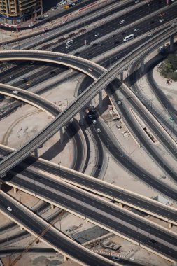 Dubai, BAE 'deki karmaşık bir otoyol kavşağının ve metro hattının havadan görüntüsü. Çölde trafik, arabalar ve üstgeçitlerle modern yol altyapısı.