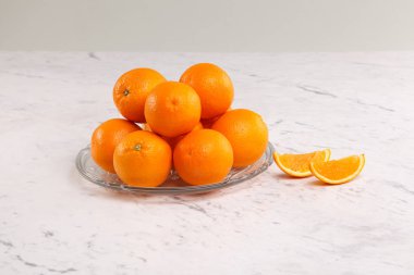 Taze pişmiş çavdar ekmeği ve kuru buğday kulaklı dilimler. Beyaz mermer arka planda geleneksel işlemeli kumaş kompozisyonu. Rustik zanaatkar fırın konsepti.