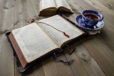 Bibles and cup of tea on wood table clipart