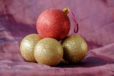 Üç Altın Noel baubles biri kırmızı ile