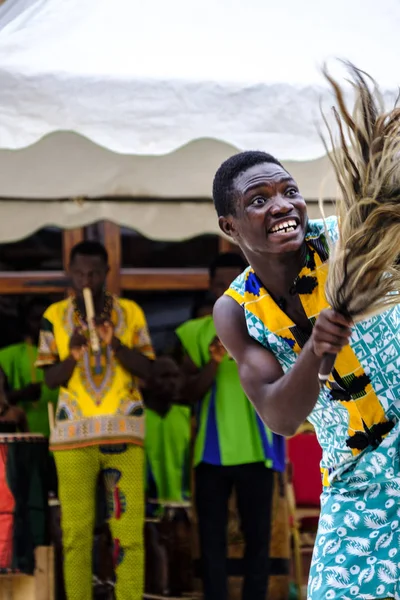 カラフルな音楽とダンスのグループは伝統的な衣装で幸せな若い男性ダンサーのエネルギーと典型的なガーナの文化パフォーマンスを与えるタコラディ ガーナ 2018 ストックフォト