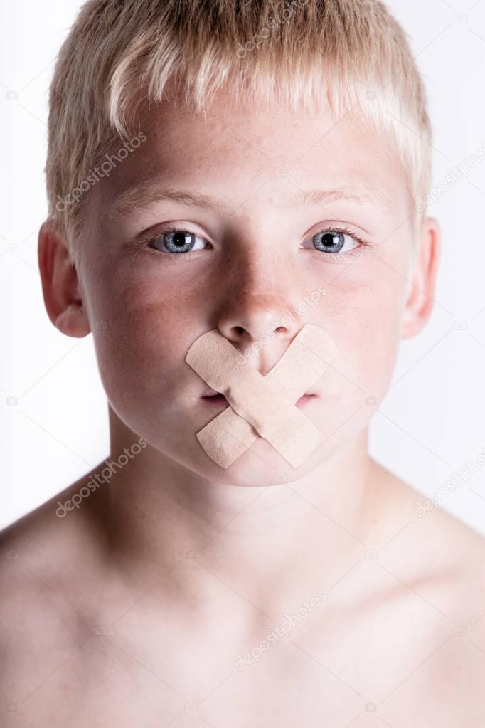Boy with adhesive tape over his mouth