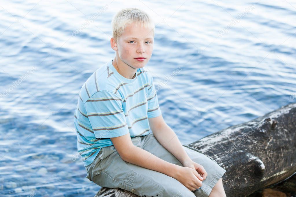 Boy sitting on a driftwood