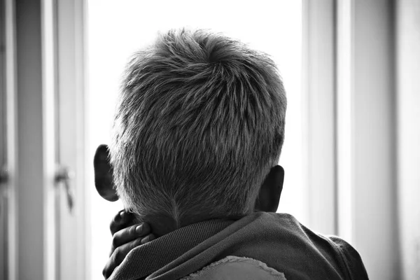 Boy looking through a window — Stock Photo, Image