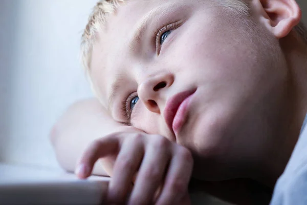 Jongen door een venster kijken — Stockfoto