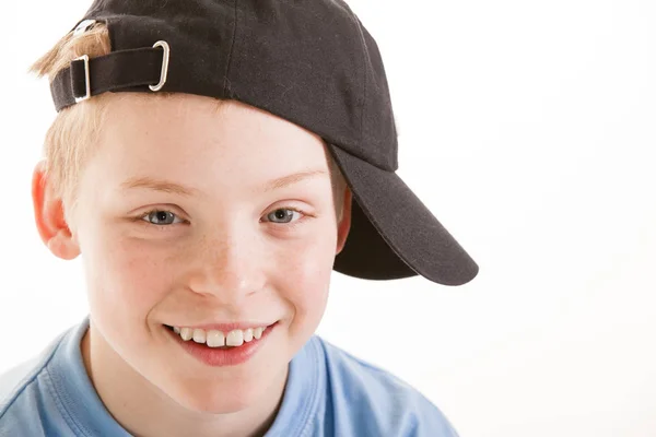 Felice sorridente ragazzo di 12 anni con un cappello isolato su schienale bianco — Foto Stock