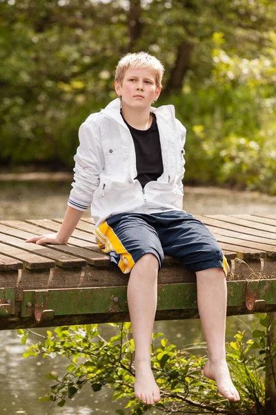 다리에 앉아 어린 소년의 초상화 — 스톡 사진