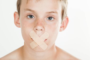 Boy with adhesive bandage across his mouth clipart