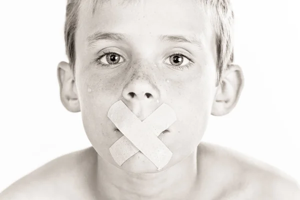 Хлопчик з клейкою пов'язкою через рот — стокове фото