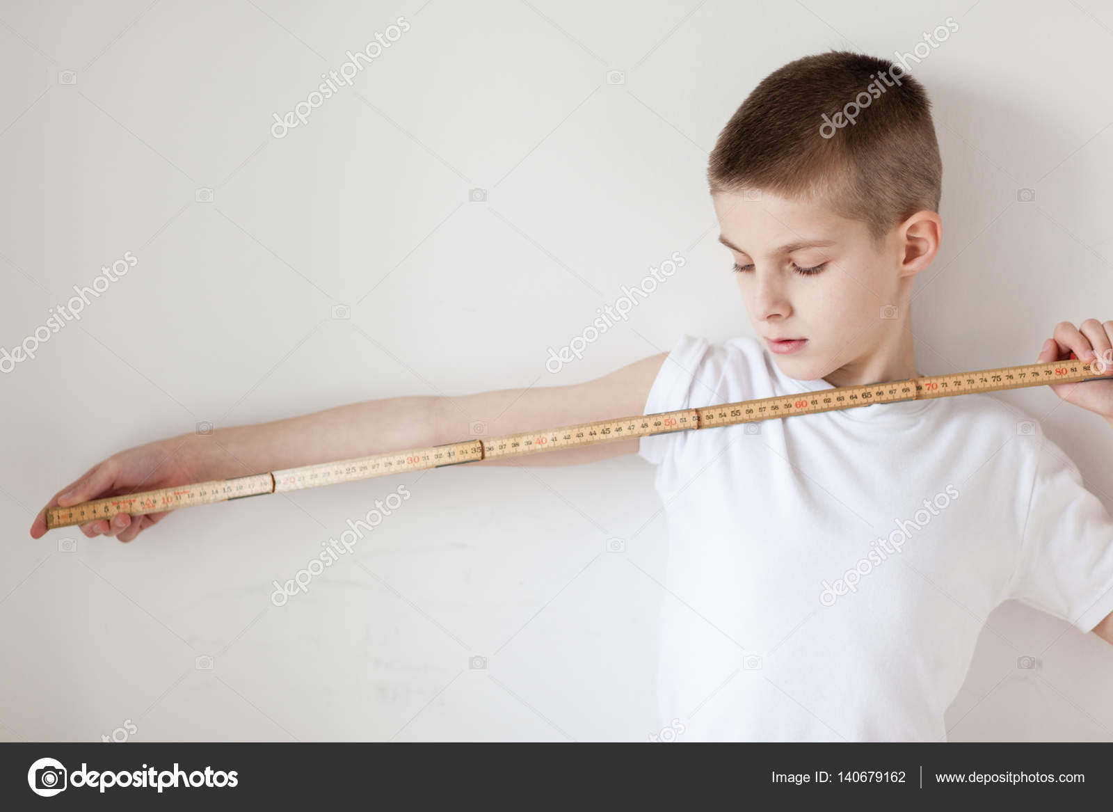 Handsome White Young Boy Holding a Meter Stick Stock Photo by