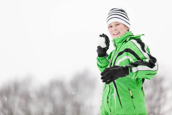 Lekfull ung pojke tar syfte med en snöboll — Stockfoto