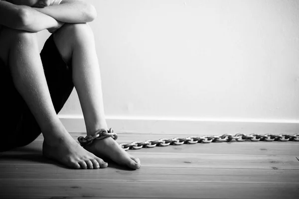 Mishandelde jongen met ketting op zijn voet in zwart-wit — Stockfoto