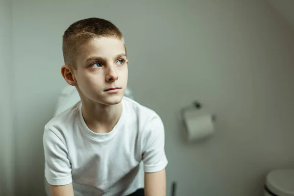 Tankfull ung pojke sitter på toaletten på allvar — Stockfoto