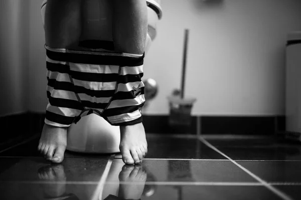 Ondergoed rond benen van een jonge jongen op een Toilet — Stockfoto