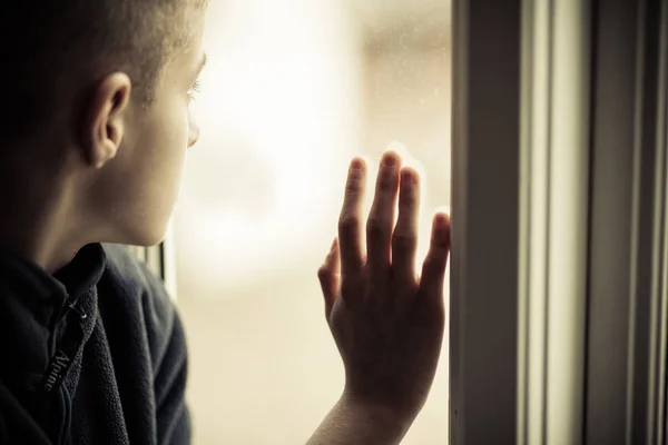 Sad Boy Looking Outside While Holding Glass Window — Stock Photo, Image