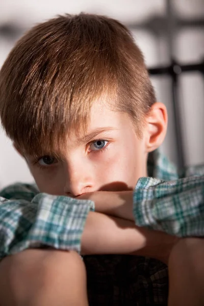 Trieste jongen met knieën omhoog kijken naar de Camera — Stockfoto