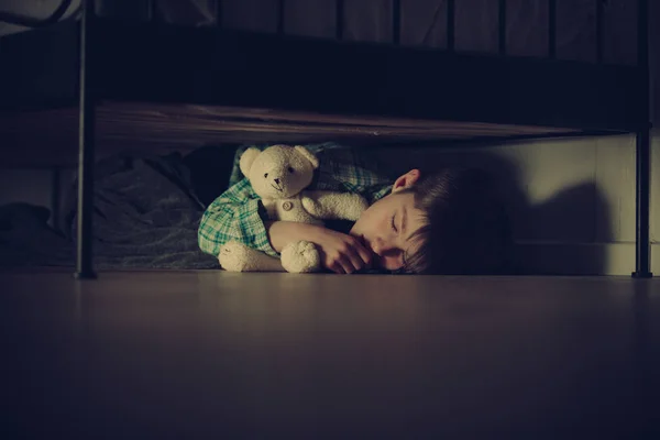 Scared Boy Sleeping Under his Bed with Teddy Bear — Stock Photo, Image