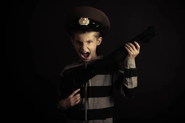 Gritando menino com policial chapéu segurando rifle — Fotografia de Stock