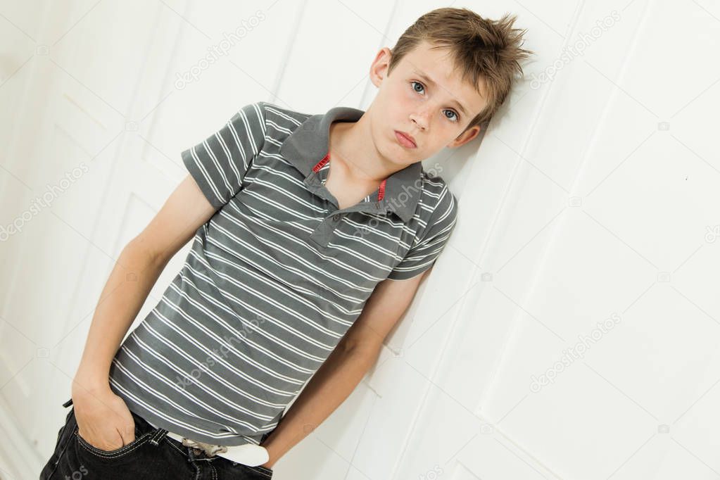 Boy leaning against the wall looking sad