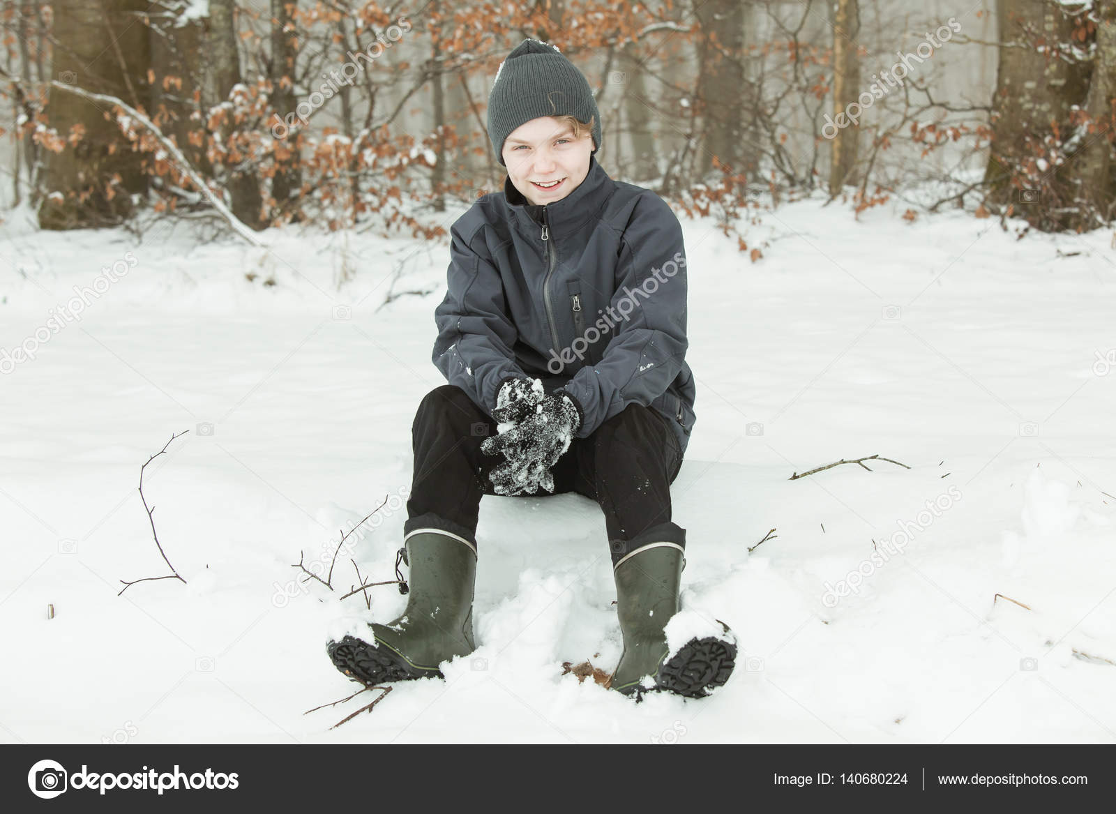 Smiling Teen Sitting In The Snow Near The Woods Stock Photo Smiling Teen Sitting In The Snow Near The Woods Stock Photo
