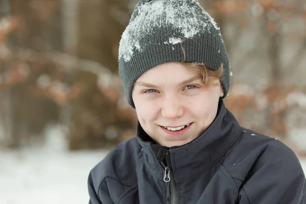 Улыбающийся счастливый мальчик, покрытый снегом — стоковое фото