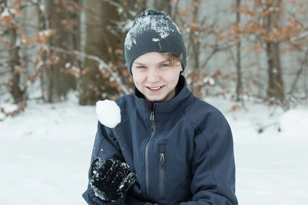 Chłopiec bawi się kuli śniegowej poza — Zdjęcie stockowe