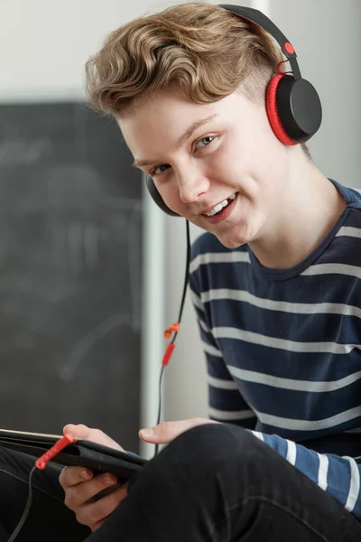 Мальчик-подросток слушает музыку через наушники — стоковое фото