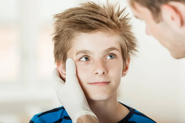医者によって若い男の子の目の検査 — ストック写真