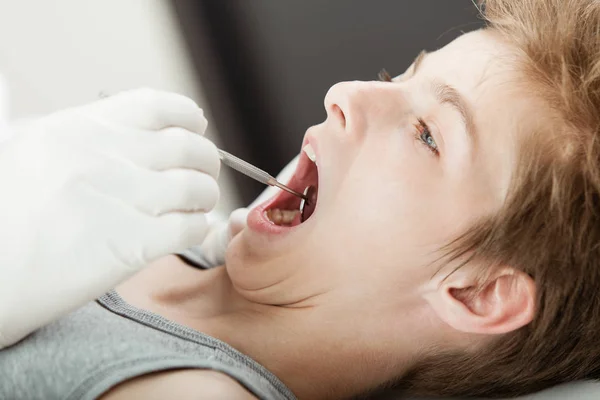 Examen de dientes de niño joven por un dentista — Foto de Stock