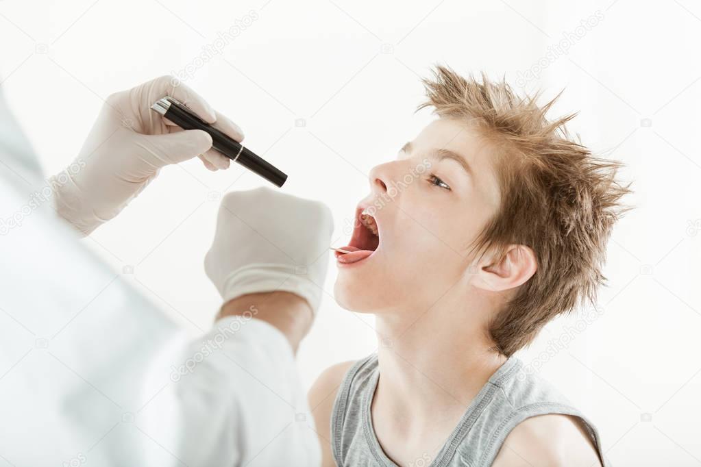 Young boy having throat examination