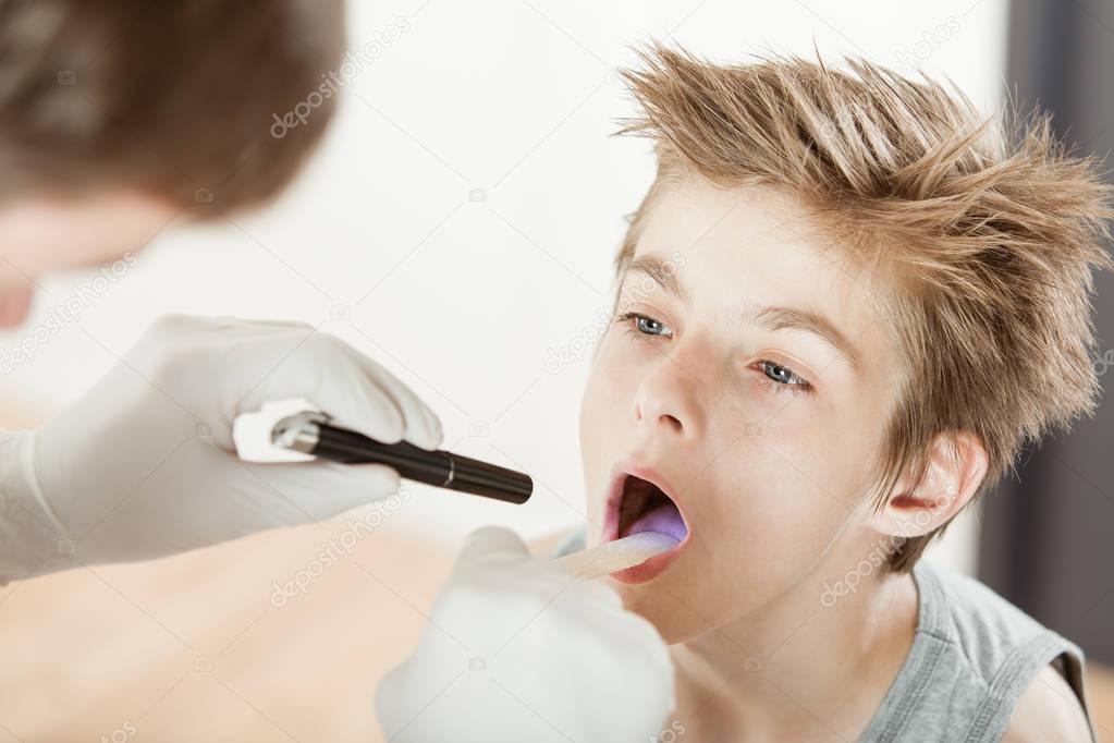 Boy attending medical throat examination