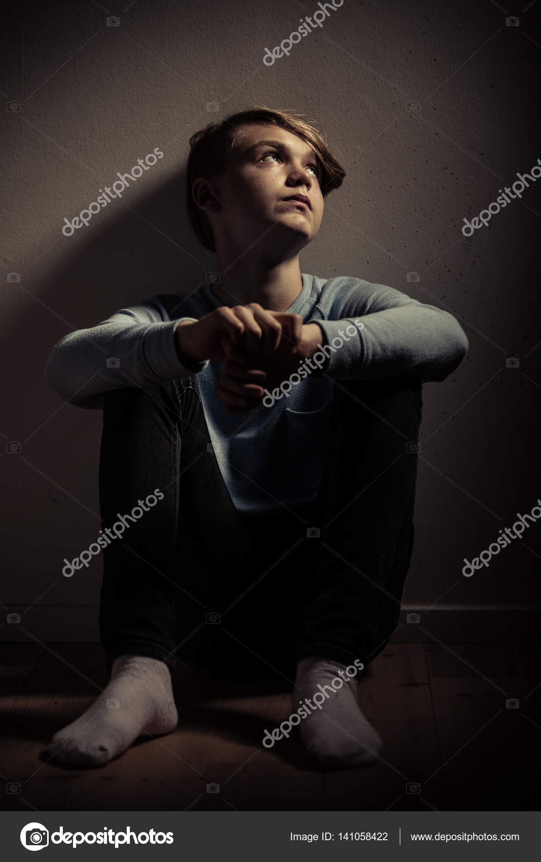 Teenage boy sitting alone in room Stock Photo by ©jhandersen 141058422