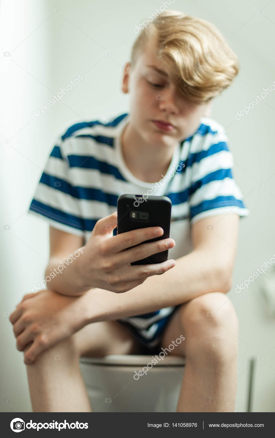 Teen using smartphone on toilet ⬇ Stock Photo, Image by 