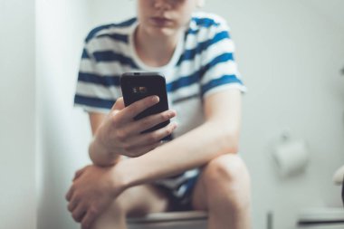 Genç tuvalet bir smartphone ile